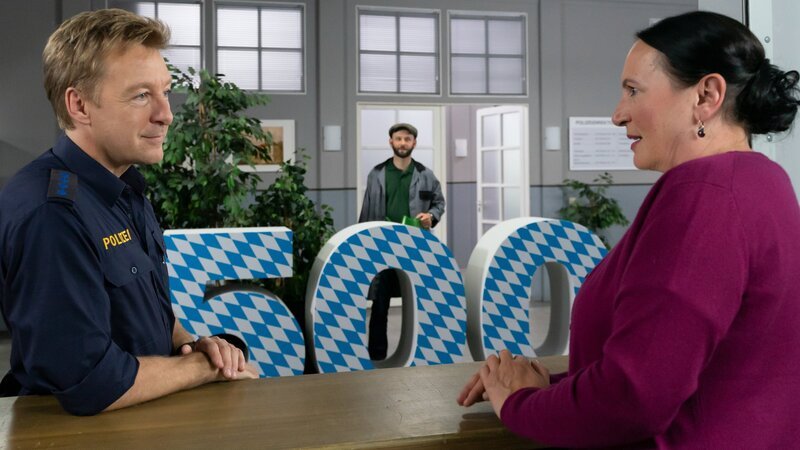 Polizeihauptmeister Mohr (Max Müller, l.) und Marianne Grasegger (Ursula Maria Burkhart, r.) wundern sich über die „500“, die Hausmeister Hannes Winkler (Steffen Wolf, M.) aufgestellt hat. – Bild: ZDF