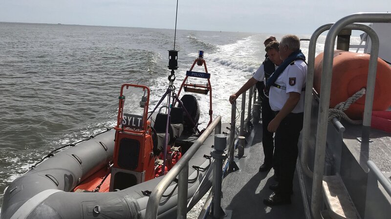Auf dem Küstenboot „Sylt“ machen die Wasserschutzpolizisten ihr Schlauboot klar. Möglichst jeder der 90 Krabbenfischer auf der Nordsee soll einmal im Jahr kontrolliert werden. – Bild: NDR/​André Schnoor