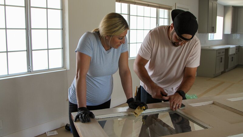 Scott helps Jasmine scrape off chipped paint from this old door, giving it more distress. – Bild: HGTV /​ Discover Images;FBOD103_7_Clarke /​ Discovery Communications