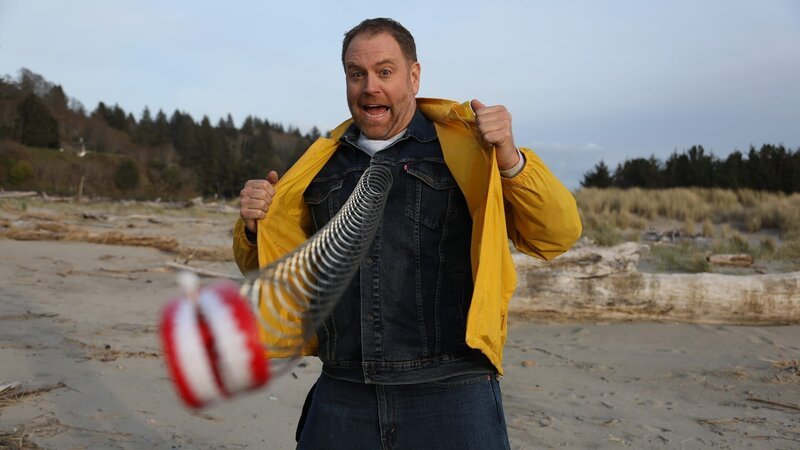Host Josh Gates opens his jacket revealing toy dentures like Data from The Goonies – Bild: Warner Bros. Discovery