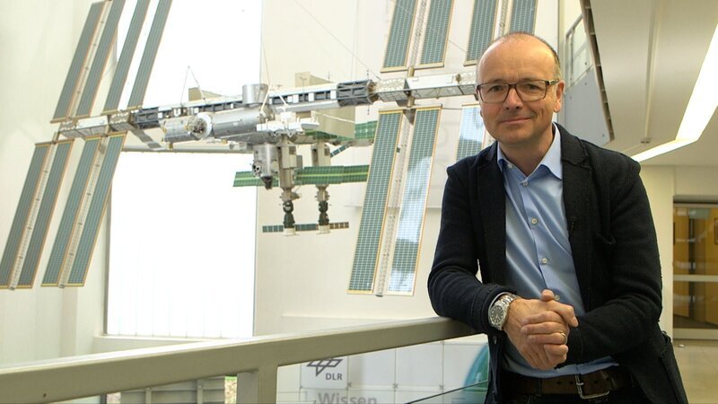 Karsten Schwanke vor einem Modell der Raumstation ISS beim Deutschen Zentrum für Luft- und Raumfahrt in Köln. – Bild: Maximilian Schecker