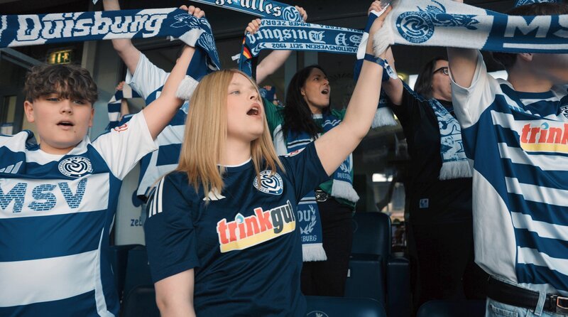 Lea Bursch (2.v.l.) beim Singen der Hymne. Für sie ist der MSV Duisburg das Größte. – Bild: WDR/​eitelsonnenschein GmbH