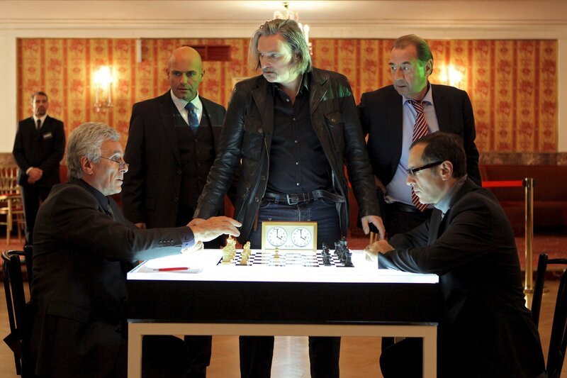Nachdem die beiden Favoriten auf den Weltmeistertitel im Schach Sorokin (Gojko Mitic, l.) und Boris Aljechin (Merab Ninidze, r.) der Bitte des Turnierveranstalters Arthur Lippmann (Michael Rast, 2.v.l), das Gebäude sofort zu verlassen, nicht nachkommen, machen Major Carl Ribarski (Stefan Jürgens, M.) und Oberst Otto Dirnberger (Dietrich Siegl, 2.v.r) den Wettstreitern den Ernst der Lage auf nachdrückliche Art und Weise klar und komplimentieren sie hinaus. – Bild: ZDF und Petro Domenigg