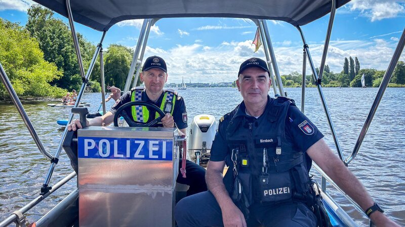 Thomas Klostermann (links) und Torsten Birnbach von der Wasserschutzpolizei in ihrem Streifenboot auf der Alster. – Bild: NDR/​Stefan Mühlenhoff