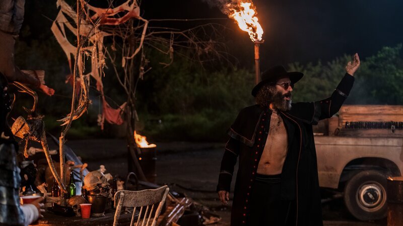 Der Prediger der Heiligen Männer (Jason Mantzoukas) fordert seine Anhänger auf, als Götter der Straßen über das Chaos zu herrschen – und ihm Gaben zu überreichen. – Bild: ZDF und Skip Bolen