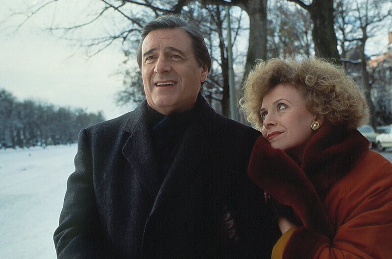 Nach dem Streit über Hund Lumpi haben sich Ilse (Ilse Neubauer) und Josef Haslbeck (Helmut Fischer) wieder versöhnt. Gemeinsam genießen sie die winterliche Stimmung am Nymphenburger Kanal. – Bild: BR/​Tatiana Film GmbH & Co. Audio KG