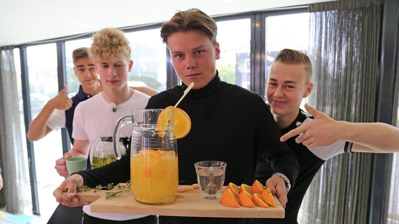 Luke, Mark, Jeppe und Alex servieren einen Anti-Erkältungstrunk. Sie sind sich sicher, davon wird ihr Mitbewohner Ruben schnell wieder gesund. – Bild: ZDF
