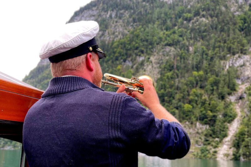 Trompeter Andreas Kunz trompetet die Echo-Wand auf dem Königssee an. – Bild: Bettina Zettler /​ BR /​ Bewegte Zeiten Filmproduktion GmbH