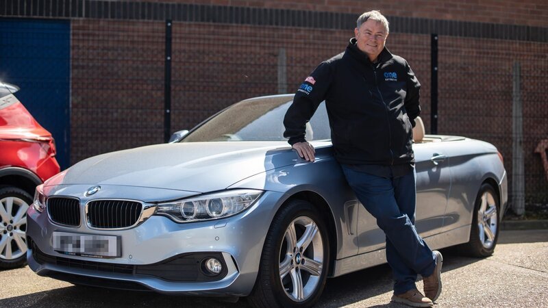 Mike poses with BMW 4 series in black jacket – Bild: Warner Bros. Discovery
