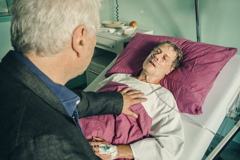 Kriminalhauptkommissar Franz Leitmayr (Udo Wachtveitl) befragt seinen alten Freund Mikesch Seifert (Andreas Lust) zum Hergang des Überfalls, bei dem Mikesch verletzt wurde. Beide sind überrascht, sich unter diesen Umständen wiederzutreffen. – Bild: Hendrik Heiden /​ BR, Wiedemann & Berg Television GmbH & Co. KG /​ BR/​Wiedemann & Berg Television GmbH & Co. KG/​Hendrik Heiden