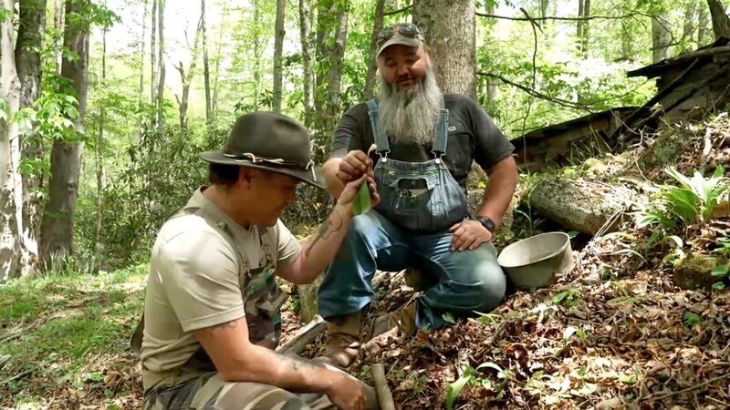 Mike Cockrell and Jerry Benson eating ramps in the woods. – Bild: Warner Bros. Discovery