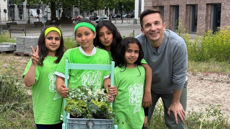 Wie können Städte zur Schwammstadt werden und besser vor Starkregen geschützt werden? PUR+ Reporter Eric Mayer testet mit vier Mädchen der Kindergruppe „Coole Kids“ in Berlin, welche Böden wieviel Wasser speichern oder durchsickern lassen. – Bild: ZDF/​Ilka Simon-Wensing