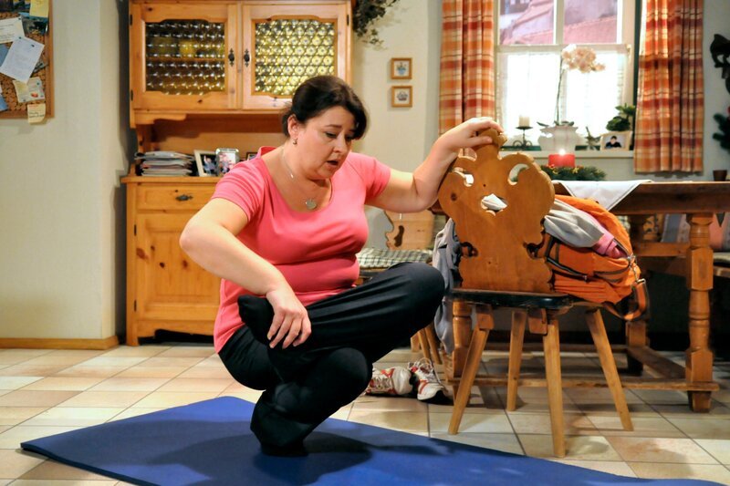 Moni (Christine Reimer) will die schwierige Yoga-Übung unbedingt meistern. – Bild: BR/​Jo Bischoff