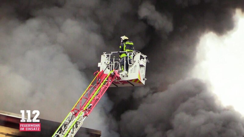 A column of black smoke hangs over the city while emergency services tries to bring the inferno under their control. – Bild: DMAX
