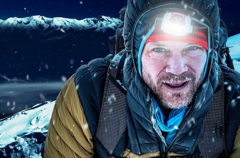Bergsteiger in winterlicher Outdoor-Kleidung mit Stirnlampe im Schneetreiben. – Bild: phoenix/​SWR/​Benedikt Böhm/​Prakash Sherpa