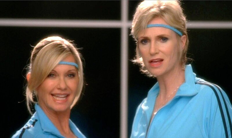 Sue (Jane Lynch, re.) schmettert zusammen mit Olivia Newton John (spielt sich selbst) den Superhit Physical. – Bild: Passion