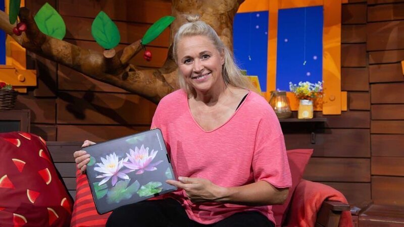 Singa schaut sich Seerosen genauer an und erklärt die Besonderheiten der Blume. – Bild: KiKA