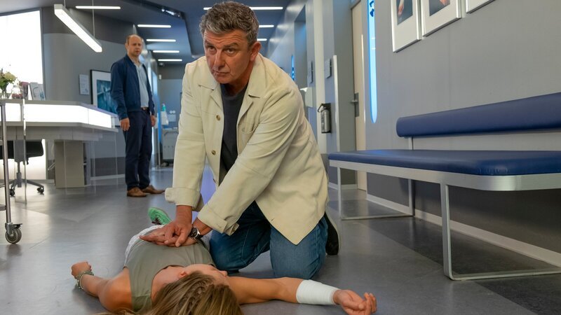 Unter den Augen ihres Bruders Michi Reichert (Moritz Führmann, l.) bricht Tina Reichert (Xenia Tiling, liegend) zusammen. Gelingt es Dr. Martin Gruber (Hans Sigl, r.) sie zu reanimieren? – Bild: ZDF