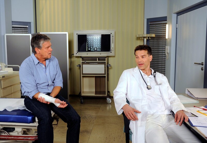 Maurice (Johannes Brandrup, r.) und Sebastian (Klaus Zmorek, l.) sind nicht gerade erfreut darüber, als Arzt und Patient aufeinander zu treffen. – Bild: ARD/​Nicole Manthey