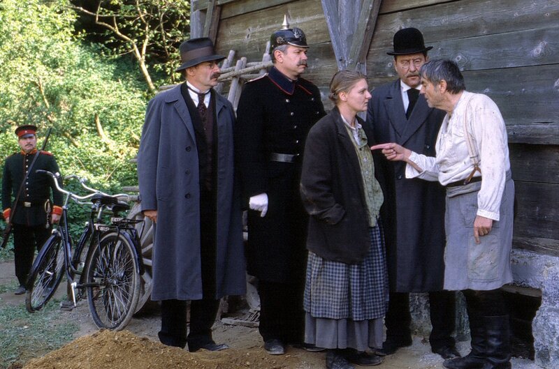 Nach zehn Jahren wird der Mordfall Gantner durch Ludwig Grandauer (Jörg Hube) aufgeklärt. von rechts: Polizist Lederer (Fred Stillkrauth), Ludwig Grandauer (Jörg Hube), Ernie Tannhäuser (Angelika Sedlmeier) und Fleischer Tannhäuser (Thomas Obster). – Bild: BR/​Tellux-Film GmbH