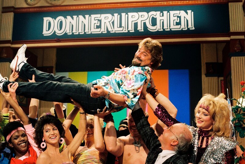 Jürgen von der Lippe wird von seinen Fans auf Händen getragen. Als Lendenwirbelstütze: Bundesarbeitsminister Norbert Blüm (Donnerlippen – Sendung von 1988). – Bild: WDR/​H. Kratzer