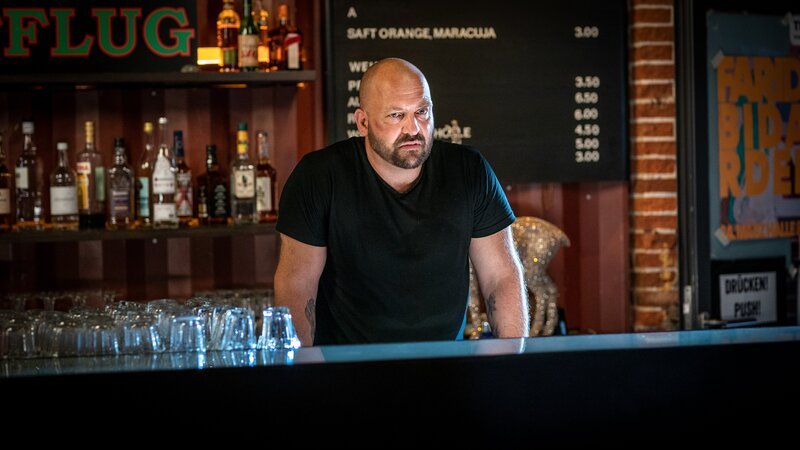 Hat Clubbesitzer Lauritz Seefeld (Urs Rechn) etwas mit der versteckten Kamera zu tun, die in der Damentoilette seines Clubs installiert war? – Bild: Boris Laewen /​ ZDF und Boris Laewen