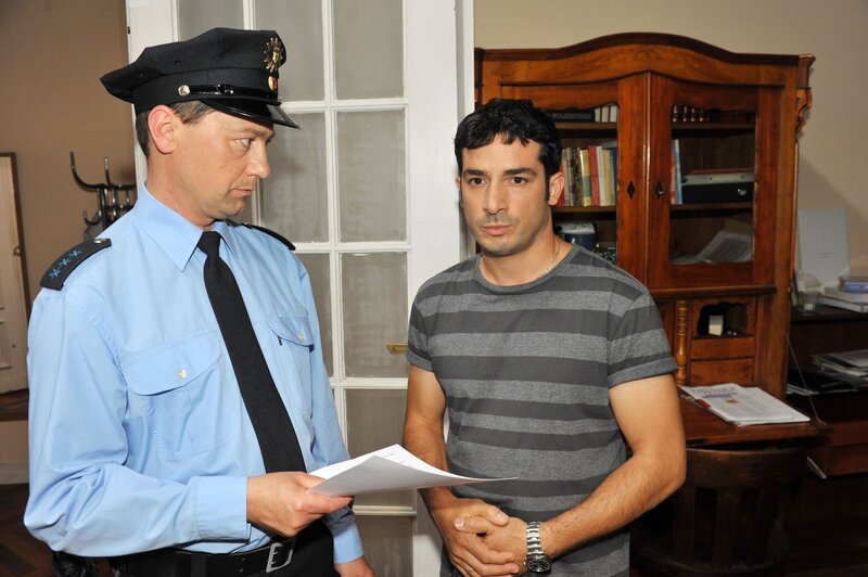 Tayfun (Tayfun Baydar, r.) ist geschockt, als die Polizei (li. Komparse) seine Wohnung durchsuchen will. Wird seine Tätigkeit als Drogenkurier auffliegen? – Bild: @RTL