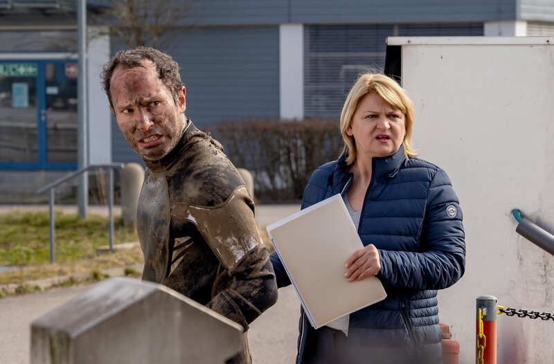 Ulrike Mettmann (Anja Stange, r. mit Benedikt Zimmermann, l.), die Leiterin der Kläranlage ist entsetzt – Riedl ist ein Missgeschick passiert. – Bild: ARD/​Thomas Neumeier