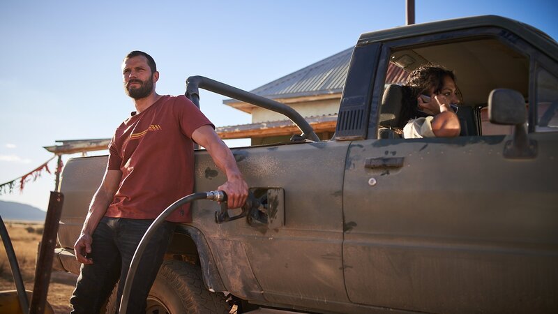 Kellnerin Luci (Shalom Brune-Franklin) hilft dem Fremden (Jamie Dornan) – aber warum eigentlich? – Bild: ZDF und Ian Routledge