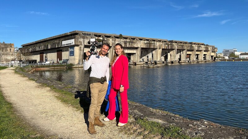 Tamina Kallert und Uwe Irnsinger (l) vor den Bassins des Lumières (Zentrum für digitale Kunst) in Bordeaux. – Bild: ZDF und WDR/​M.E. Works GmbH