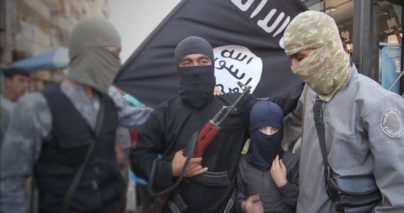 Kämpfer des so genannten Islamischen Staates posieren vor ihrer Fahne. – Bild: Tobias Lenz, Autorenkombinat /​ ZDF und Tobias Lenz, Autorenkomb