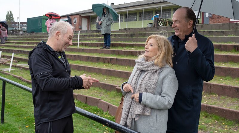 Der ehrenamtliche Fußballtrainer Achim Voss (Michael Lott, l.) braucht die Hilfe der Anwälte Isabel von Brede (Sabine Postel, 2.v.r.) und Markus Gellert (Herbert Knaup, r. mit Komparsen, h.). – Bild: ARD/​Christine Schroeder