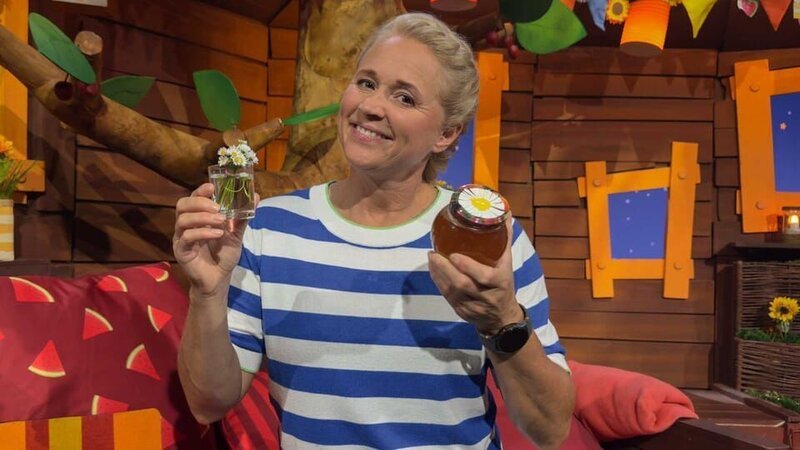 Singa erklärt, wie du aus Gänseblümchen etwas machen kannst, das fast wie Honig ist. Wie der selbstgemachte Blütensirup wohl schmeckt? – Bild: KiKA