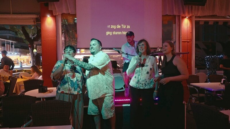 Ein Karaoke-Abend in Jesolo steht an. Plötzlich heißt es Rampenlicht statt Campingstuhl – und selbst die sonst so schlagfertigen Mamas bekommen Lampenfieber. Wagen sie den großen Auftritt?; Ein Karaoke-Abend in Jesolo steht an. Plötzlich heißt es Rampenlicht statt Campingstuhl – und selbst die sonst so schlagfertigen Mamas bekommen Lampenfieber. Wagen sie den großen Auftritt? – Bild: RTLZWEI