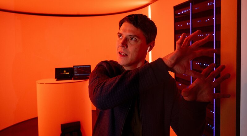 Digitales Desaster: Als ein ungewöhnlicher Notruf die Zentrale erreicht, der KI-Unternehmer Danny Nolte läge tot im Smart Home-Kontrollraum seiner Wohnung, macht sich Rico Sander (Benjamin Strecker) sofort auf den Weg zum Tatort. Dort stellt sich heraus, dass der Anrufer kein Mensch, sondern ein hochintelligentes Smart Home-System namens FRANK (Stimme: Patrick Winczewski) war. Hat FRANK sich etwa gegen seinen Schöpfer aufgelehnt und diesen ermordet? – Bild: MARKUS_FENCHEL /​ ZDF und MARKUS_FENCHEL /​ Honorarfrei – nur für diese Sendung inkl. SocialMedia bei Nennung ZDF und MARKUS_FENCHEL