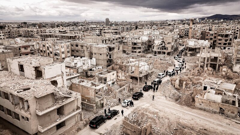 Auf ihrer Reise im März 2025 besucht Außenministerin Baerbock Dschobar, einen nahezu völlig zerstörten Stadtteil der Stadt Damaskus in Syrien. Ihre Kolonne parkt in den Trümmern. – Bild: ORF/​ZDF/​Jan Müller