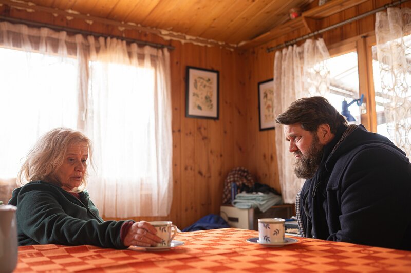 Stella Voss (Bettina Kaminski) und Benjamin Hornberg (Antoine Monot) sitzen sich in der Gartenlaube gegenüber und sprechen über die Geheimnisse ihres verstorbenen Sohnes Gio. Zwischen ihnen steht mehr als nur eine Tasse Kaffee – es geht um die Frage, was Gio wirklich verborgen hat. – Bild: Daniel Dornhöfer /​ ZDF und Daniel Dornhöfer