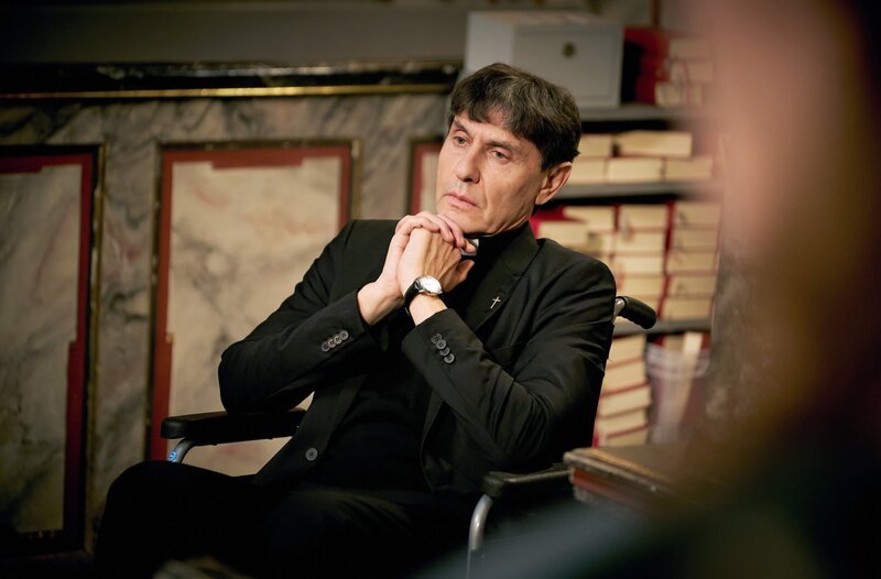 Chorprobe: Auch Carola singt mit. Aaron auf der Kirchenbank. Lara wird intensiv v. Pfarrer Schlag betrachtet Pfarrer Roman Schlag (Marc Zack – Bild: WDR/​Guido Engels /​ WDR Kommunikation/​Redaktion Bild