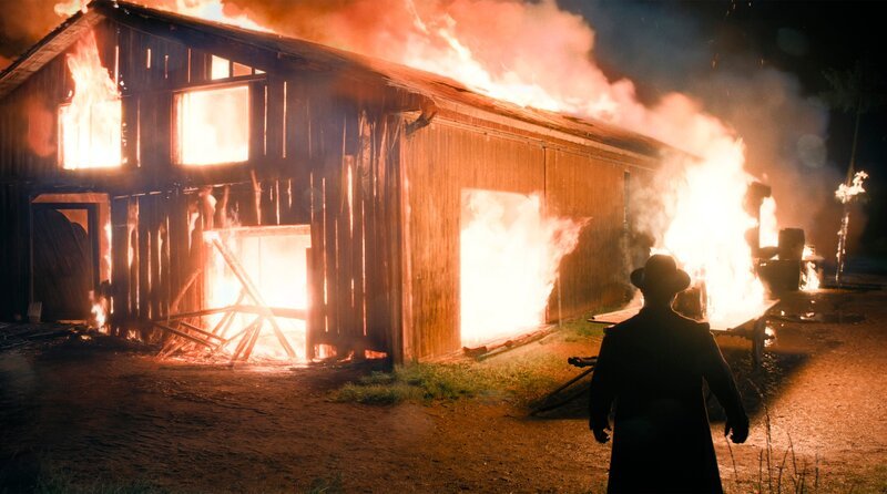 Flammendes Inferno. Hilflos muss Curt Prank (Mišel Matičević) mit ansehen, wie die Lagerhalle des Prank-Collosseums samt Achterbahn abbrennt. – Bild: BR/​ARD Degeto Film GmbH/​MDR/​Zeitsprung Pictures GmbH/​Michael Kotschi