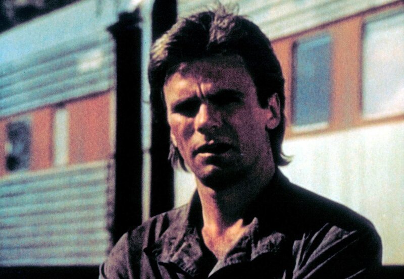 MacGyver (Richard Dean Anderson) wartet ungeduldig am Bahnhof … – Bild: Paramount Pictures