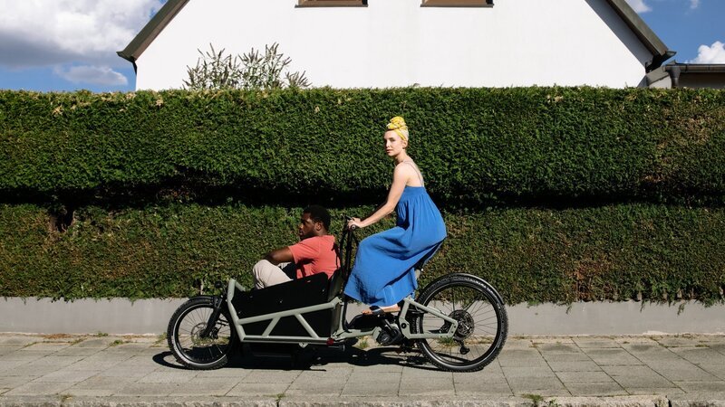 Dawit (Akeem van Flodrop) will sich und den anderen beweisen, dass er es nicht nötig hat, die alten Hemden von Nachbar Lars (Pablo Sprungala) zu tragen. Aus Protest gönnt er sich ein viel zu teures Rennrad! Als seine Frau Laura (Sina Martens) das sieht, steht schnell fest: Das kann Dawit nicht behalten. Sie brauchen ein Rad, das familientauglich ist. – Bild: ZDF