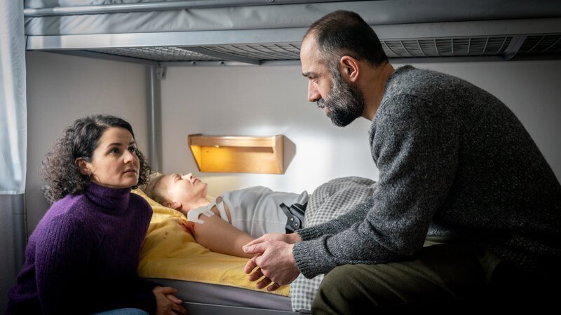 Dr. Alighieri (Nagmeh Alaei, l.) und Vasilis Georgiou (David A. Hamade, r.) unterhalten sich, nachdem Helen Dorn (Anna Loos M.) verarztet wurde. – Bild: Georges Pauly /​ ZDF und Georges Pauly