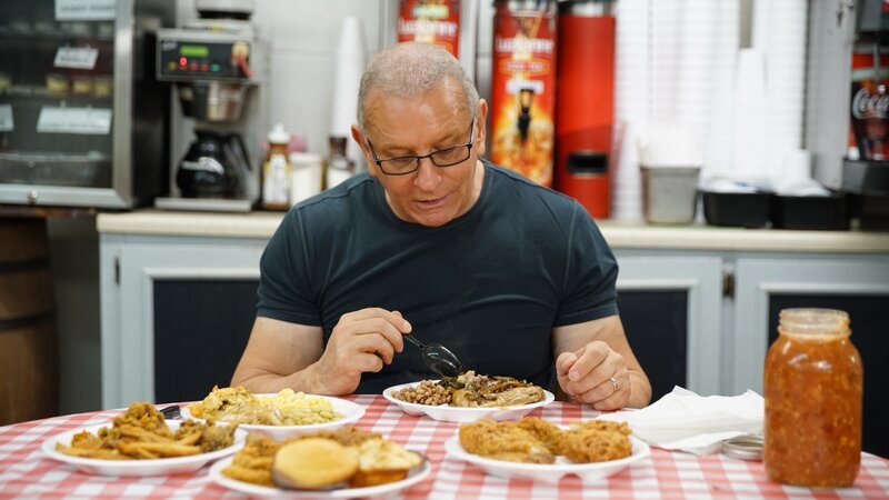 Chef Robert Irvine samples menu items at Walters Gas and Grill, prior to renovations, as seen on Restaurant Impossible, season 20 – Bild: Food Network /​ Discover Images: IL2023_RI2023_0 /​ Discovery, Inc. All Rights Reserved.