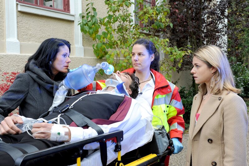 ARD STURM DER LIEBE FOLGE 1670, Doris (Simone Ritscher, l.) und Marlene (Lucy Scherer, r.) begleiten Konstantin (Moritz Tittel, M. mit Komparsin) zum Krankenwagen. – Bild: ARD/​Ann Paur