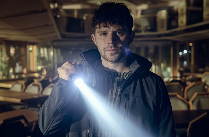 Lenny Lindegger (Simon Morzé) sucht auf dem für den Winter stillgelegten Ausflugsschiffs nach Spuren seines verschwundenen Onkels. – Bild: BR/​ARD Degeto Film/​Hager Moss Film GmbH/​Marco Nagel