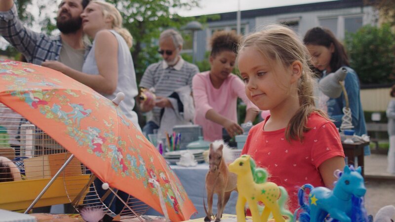 Klara (Paulina Pizarro Swartling) will auf dem Flohmarkt in der Nachbarschaft ein Meerschweinchen kaufen. – Bild: KiKA/​Erik Vallsten
