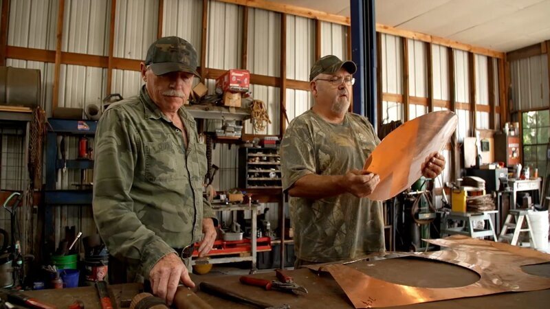Mark Rogers and Huck Stewart in the workshop making a copper still. – Bild: Warner Bros. Discovery