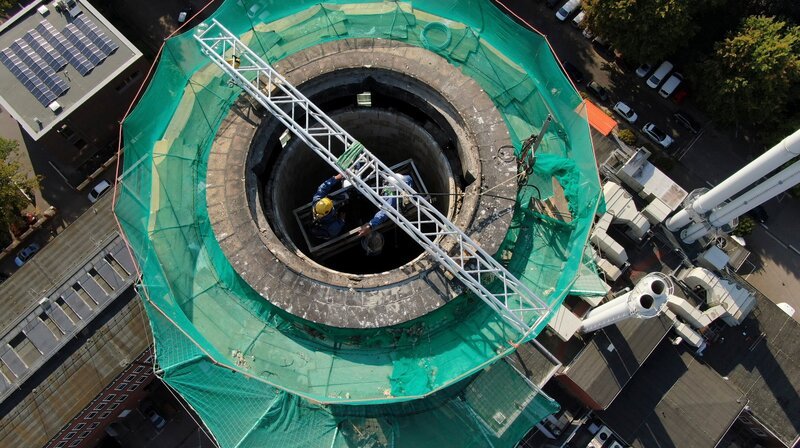 Das Innenfutter des Schornsteins wird per Handarbeit weggehauen. – Bild: NDR/​TOB Filmproduktion/​Tim Boehme