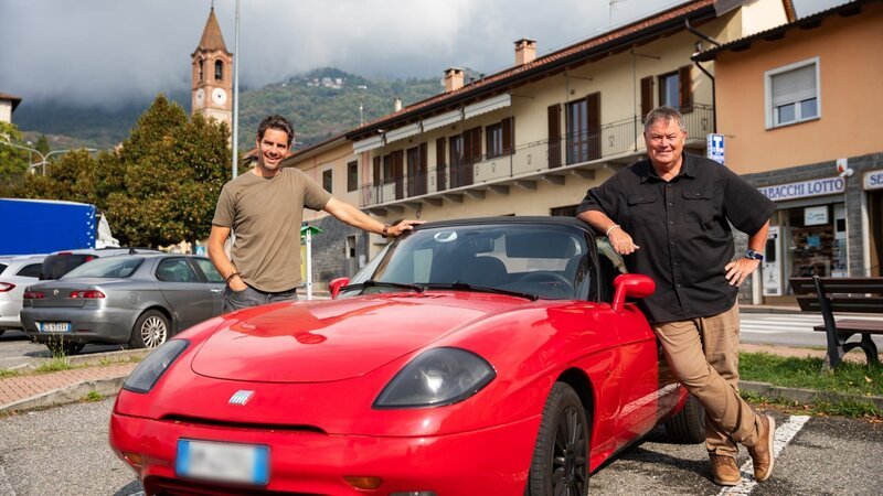 MS hero front shot of Fiat Barchetta pre works with Mike Brewer and Marc ‚Elvis‘ Priestley either side of car in Villar Dora, Italy – Bild: Warner Bros. Discovery