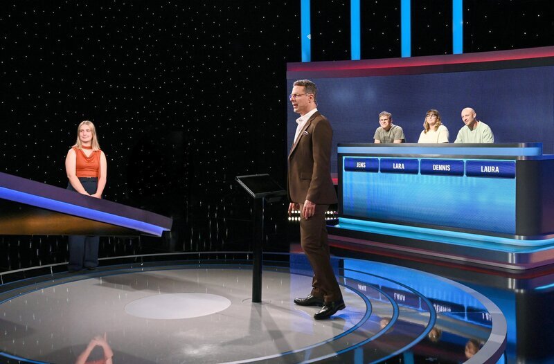 Moderator Alexander Bommes (M.) mit den Kandidat:innen: Jens Meißner (3.v.r.), Lara Saupe (2.v.r.), Dennis Enter (r.), Laura Klösen (l.). – Bild: ARD/​Uwe Ernst